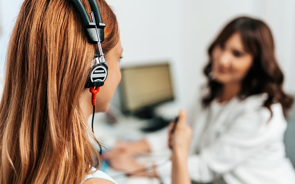 Audiologist doing impedance audiometry or diagnosis of hearing impairment.