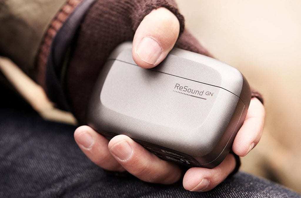 Banner image of a person holding ReSound hearing aids