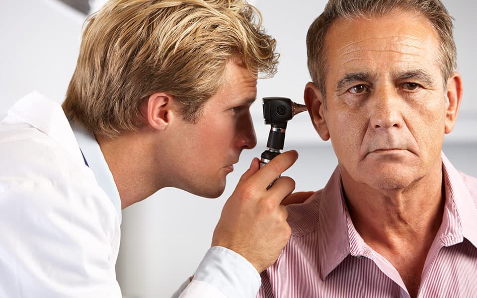 Doctor Examining Male Patient's Ears