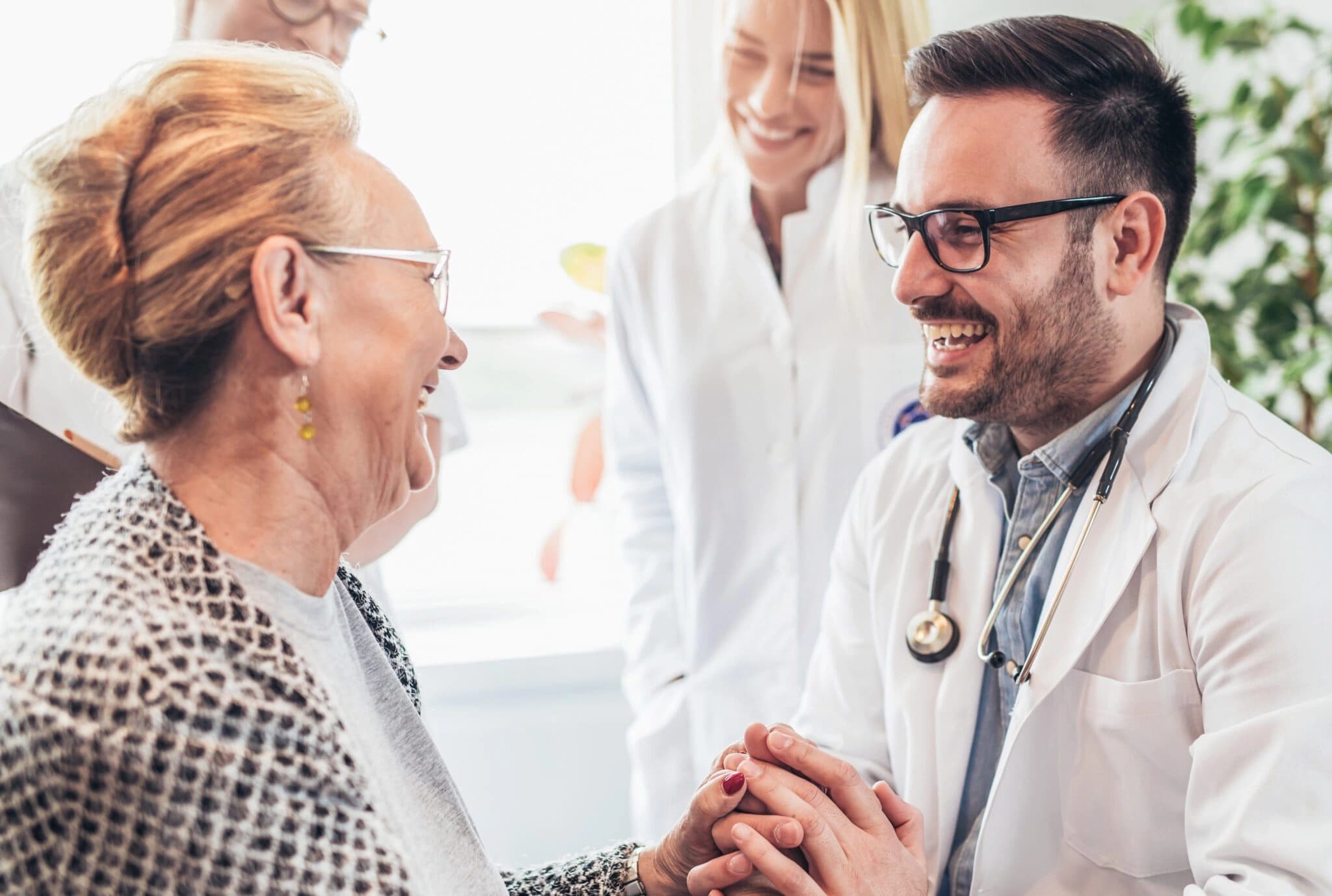 Doctor holding happy woman's hands