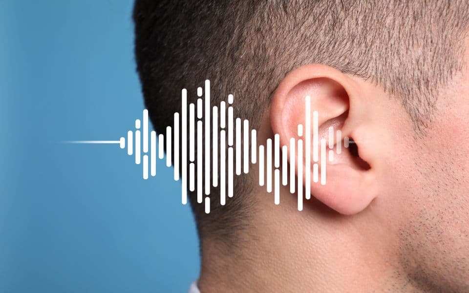 Close-up of a man's ear with a sound wave illustration to show the concept of hearing loss