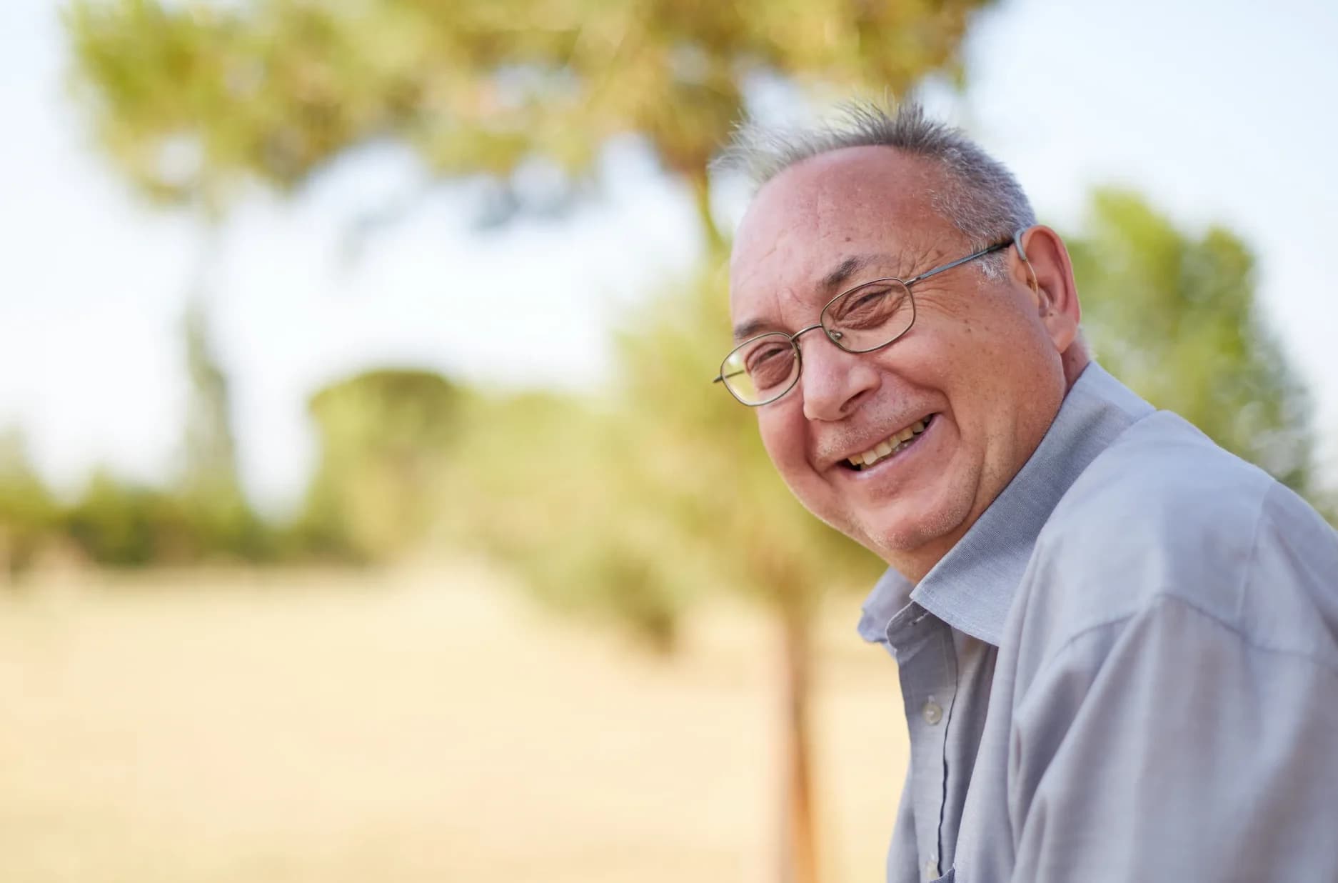 Gentleman with hearing aid enjoying the outdoors.