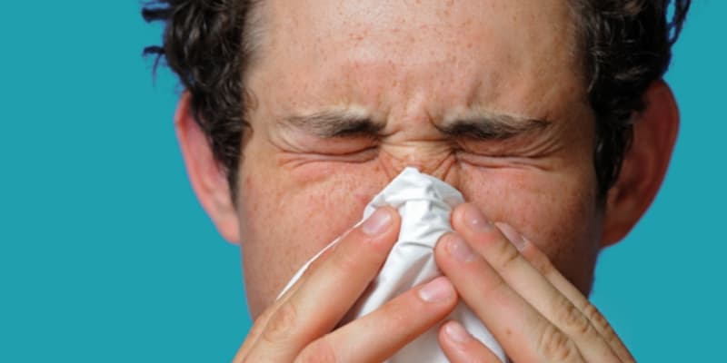 man blowing his nose