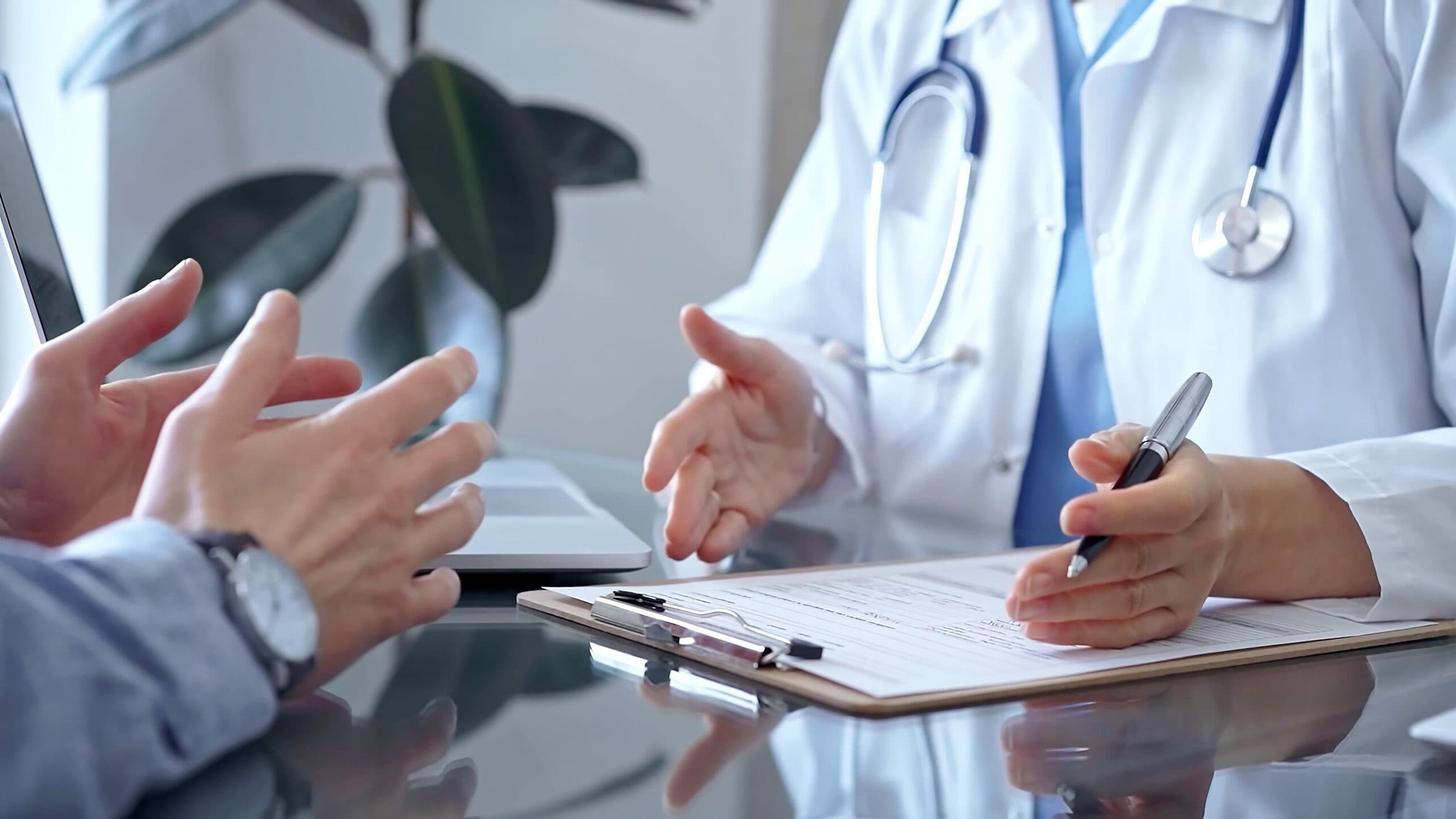 An image of a man speaking to his doctor across a desk discussing the hearing evaluation process