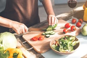 Senior woman cutting vegetables in the kitchen