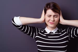 Women holding hands over ears