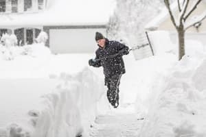 Man shoveling snow in a driveway