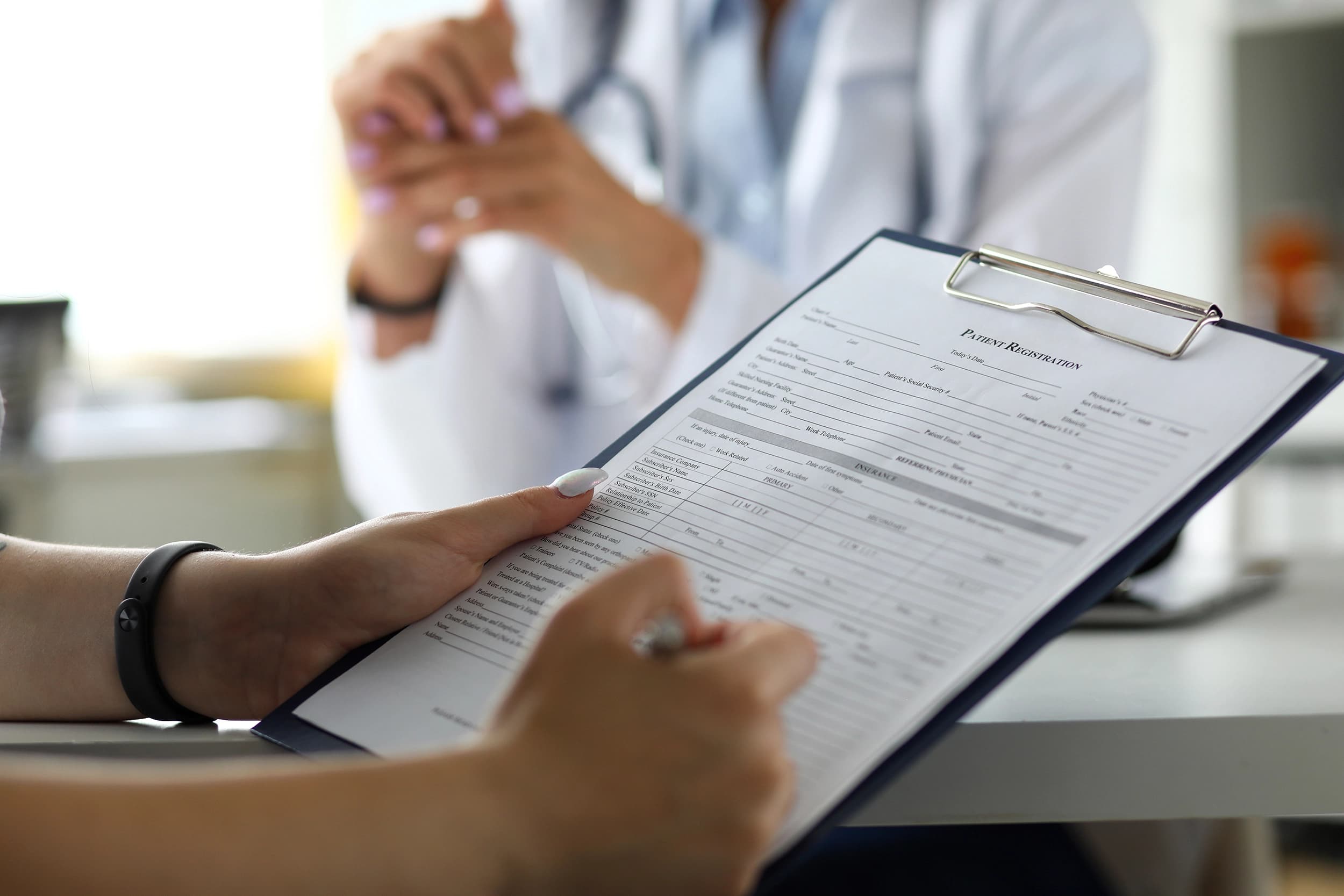 Person filling out medical paperwork on a clipboard