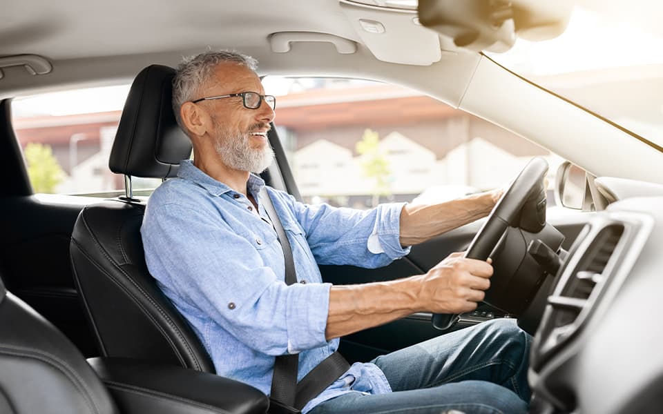 Senior man with glasses driving his car