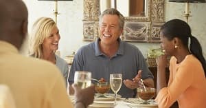 Smiling friends eating at a dinner party