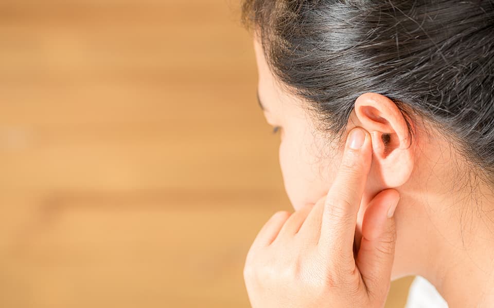 Female having ear pain touching his painful head
