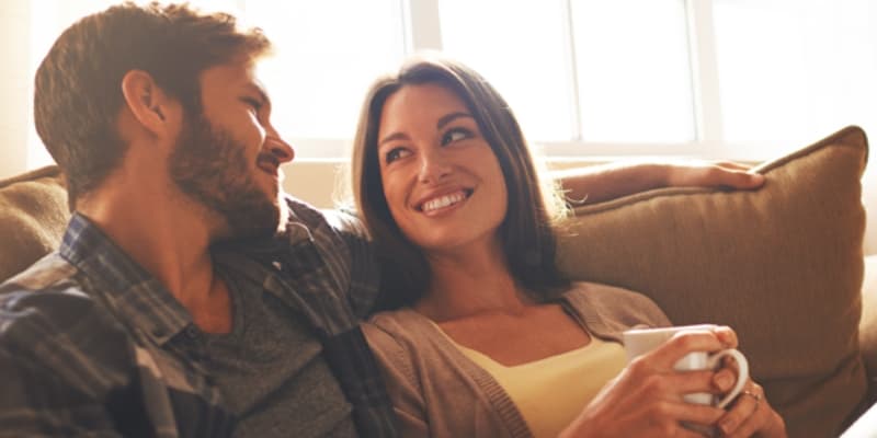 couple smiling and sitting together on a couch