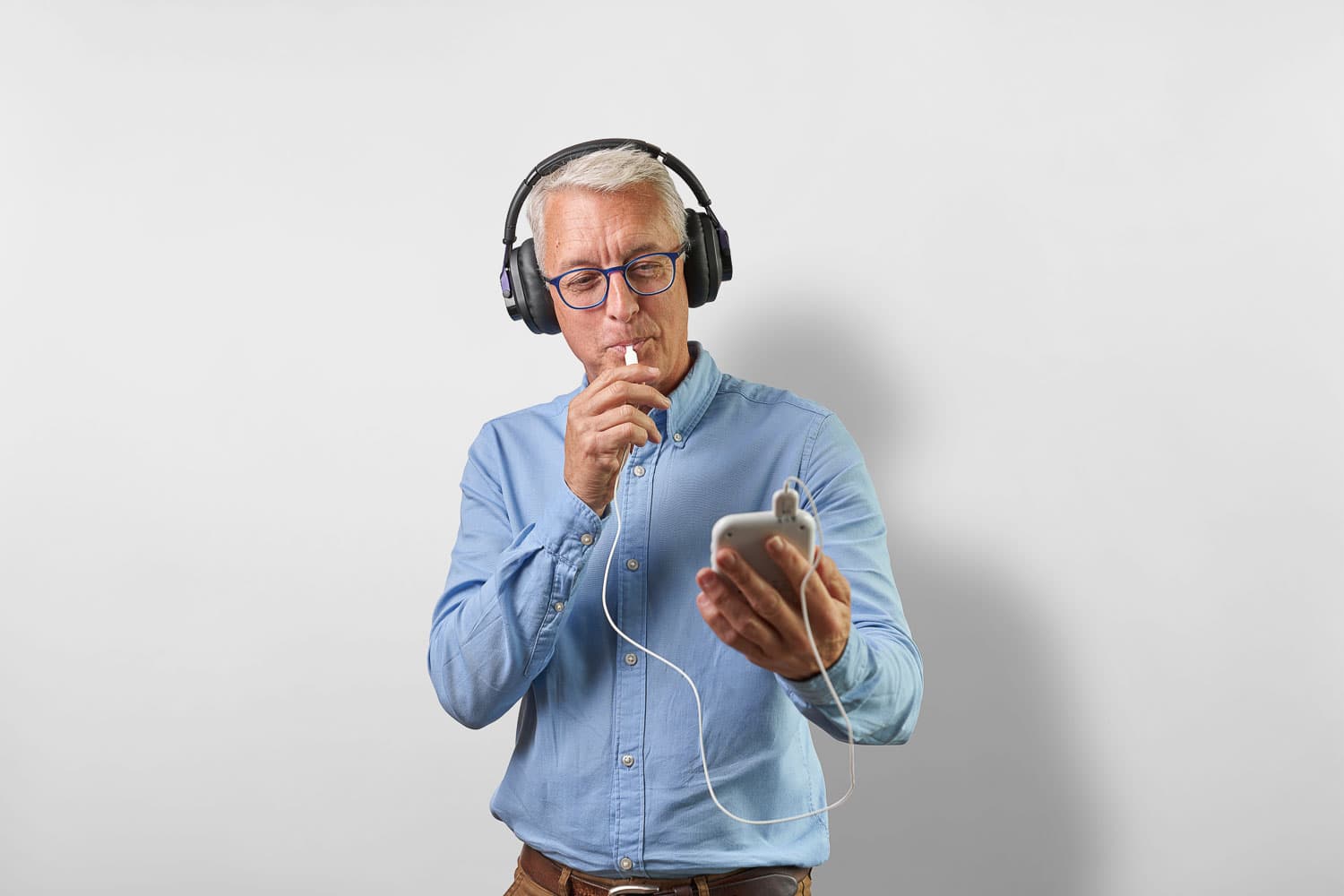 Image of a man using a Lenire device with an over-ear headset and Tonguetip insert.