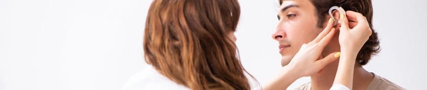 Man being fitted for a hearing aid by a doctor