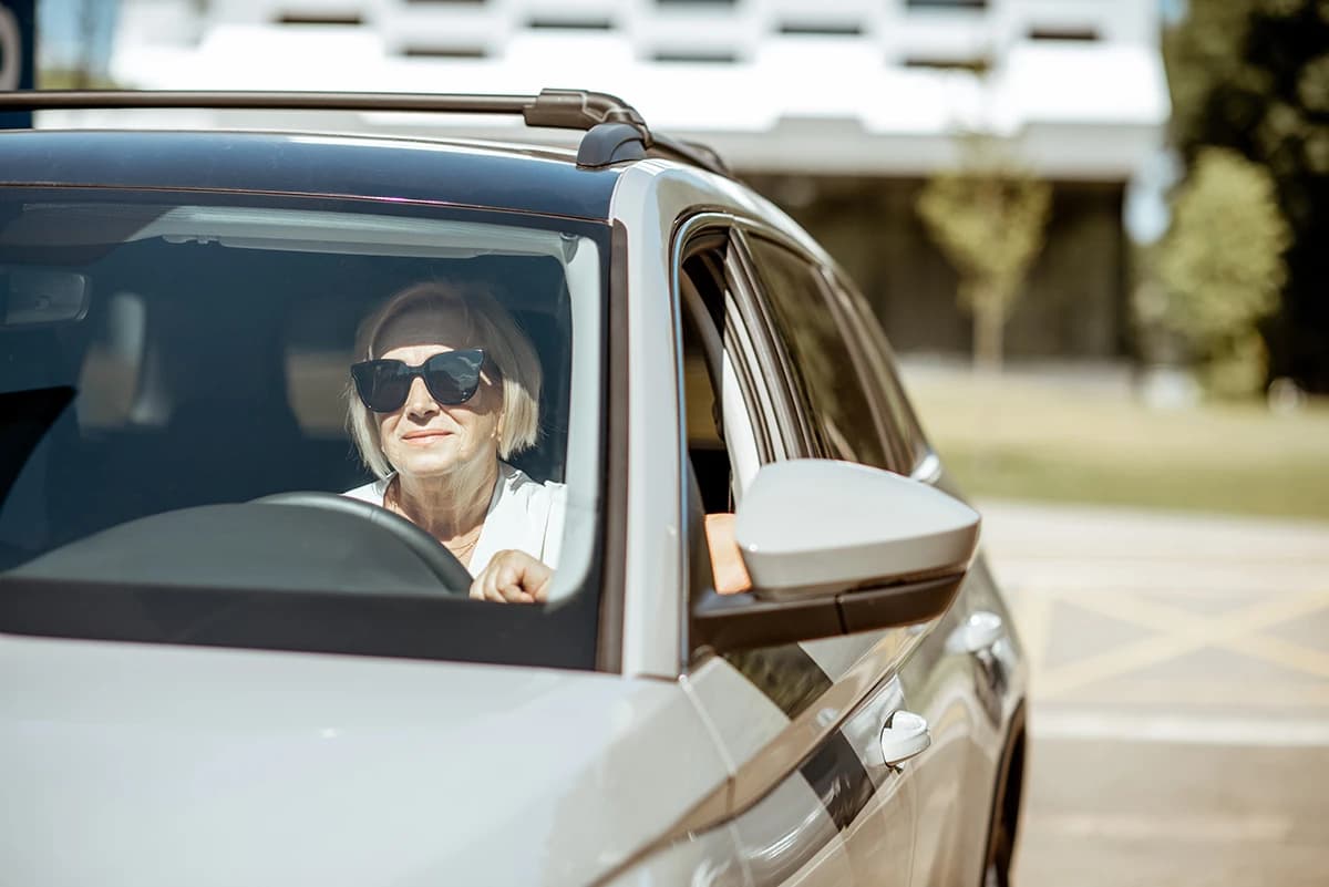 older woman enjoying a car drive